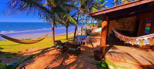 uma casa na praia com redes e o oceano em Casa da Peroba Sol em Icapuí