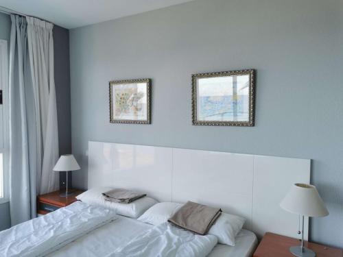 - une chambre avec 2 lits et 2 photos sur le mur dans l'établissement Family Sun Seasight Apartment, à Cala Millor