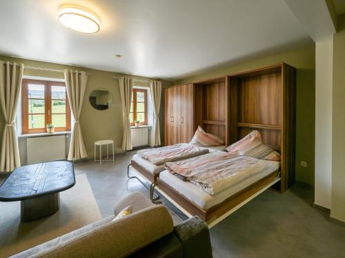 1 Schlafzimmer mit 2 Betten und einem Sofa in der Unterkunft A Mëchels in Bettel