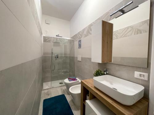 La salle de bains est pourvue d'un lavabo, de toilettes et d'une douche. dans l'établissement Bnbook Lattuada 3 camere da letto 2 bagni, à Rho