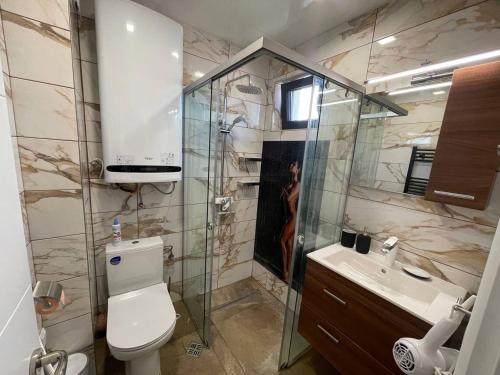 a bathroom with a shower and a toilet and a sink at Panoramic apartment in Varna with underground parking in Varna City