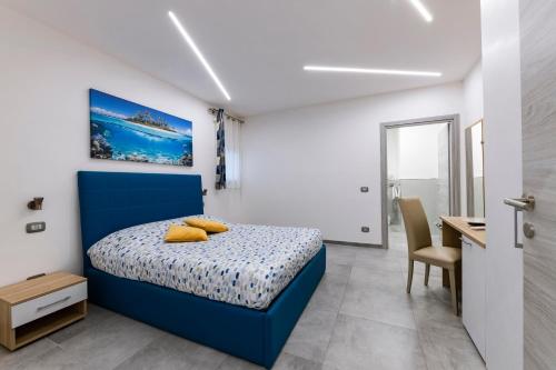 een slaapkamer met een blauw bed en een bureau bij BNB Aria di Mare in Santa Marinella