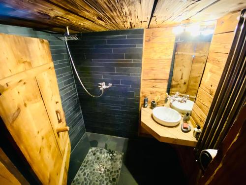 a small bathroom with a sink and a mirror at Zum Stillen Unicum in Axalp