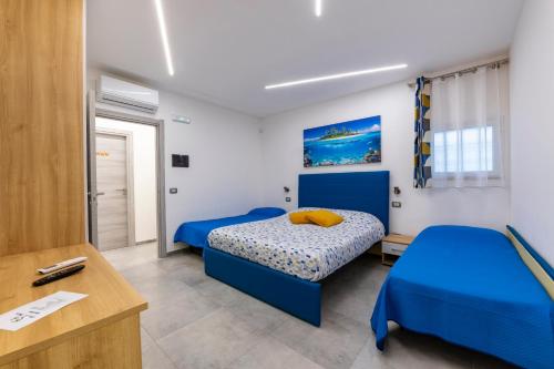 sypialnia z 2 łóżkami i biurkiem w obiekcie BNB Aria di Mare w mieście Santa Marinella