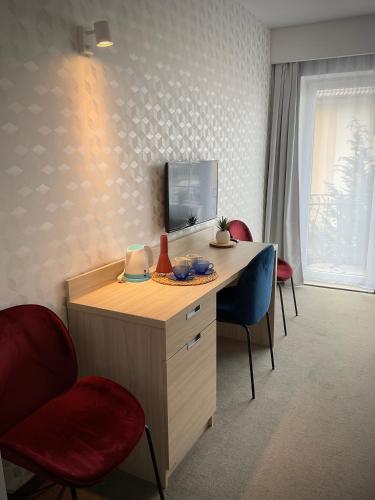 a room with a desk with chairs and a television at WiLLA APART in Władysławowo