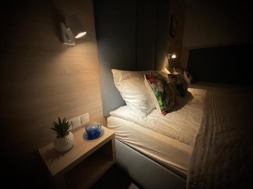 a small room with a bed and a night stand at WiLLA APART in Władysławowo