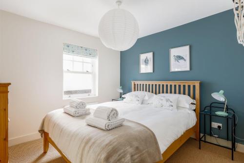 a bedroom with a bed with towels on it at Lobster Cottage in Poole