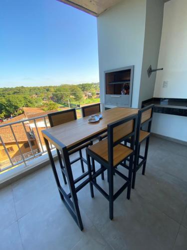 drewniany stół i krzesła w pokoju z balkonem w obiekcie Cómodo apartamento nuevo, zona aeropuerto! w mieście Luque