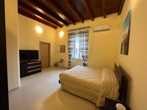a bedroom with a bed and a flat screen tv at IN CENTRO Rooms and Apartments in Isola del Liri