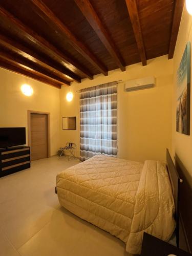 a bedroom with a bed and a large window at IN CENTRO Rooms and Apartments in Isola del Liri