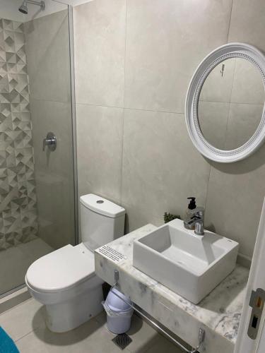 a bathroom with a sink and a toilet and a mirror at Cómodo apartamento nuevo, zona aeropuerto! in Luque
