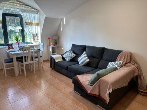 a living room with a blue couch and a table at Ático de Carmen in Cee