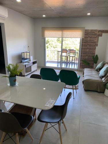- un salon avec une table, des chaises et un canapé dans l'établissement Cómodo apartamento nuevo, zona aeropuerto!, à Luque
