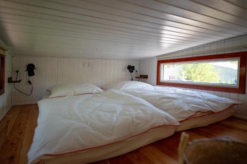 a large white bed in a room with a window at Tiny House 300 Meter vom Zentrum entfernt in Eberswalde