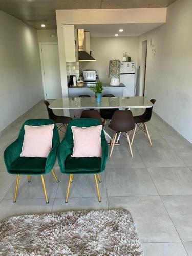 a kitchen and dining room with green chairs and a table at Cómodo apartamento nuevo, zona aeropuerto! in Luque