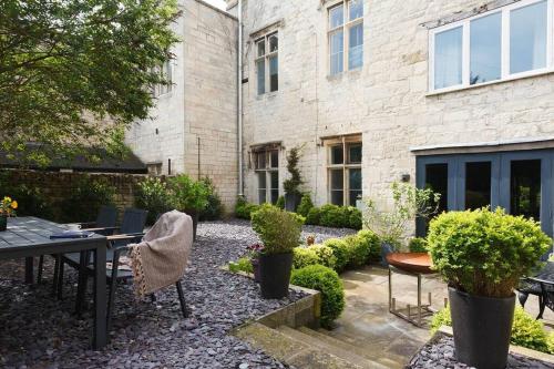 a garden with a table and chairs in front of a building at A beautiful Georgian town house in Painswick in Painswick