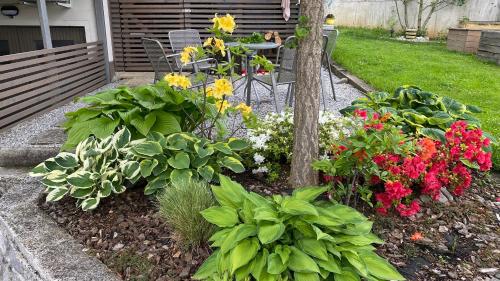 a garden with colorful flowers and a table and a table sidx sidx sidx at Apartma Nomad in Novo Mesto