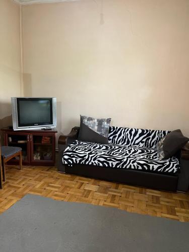 a living room with a black and white couch and a tv at Guest House SAMAN in Garni