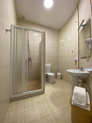 uma casa de banho com um chuveiro, um lavatório e um WC. em Parus em Chernivtsi