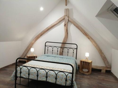 a bedroom with a black bed in a attic at La romance de Laura in Arrest