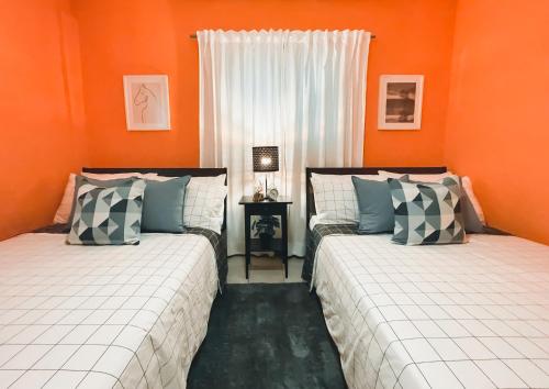 ハラバコアにあるCasa del Arroyo 2-Bedroom Cottage Fireplace and BBQのオレンジ色の壁の客室内のベッド2台