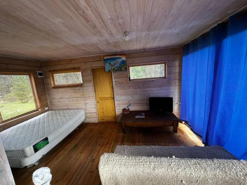 una habitación con una cama y una mesa en una cabaña en Pacífico Cono Surf, en Puertecillo