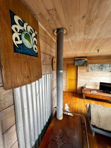Cabaña de madera con sala de estar con chimenea en Pacífico Cono Surf, en Puertecillo