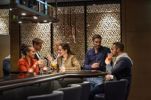 a group of people sitting at a bar at Maritim Hotel Ingolstadt in Ingolstadt