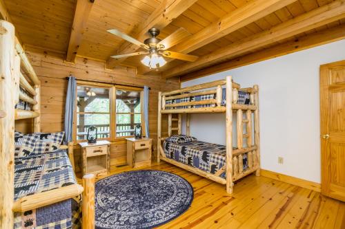 Dormitorio en cabaña de madera con literas y ventilador de techo en New Listing! Lakeview Lodge - 5 Bed, 4 Bath - Hot Tub, en Dahlonega