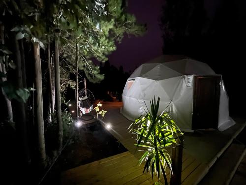 - un parasol blanc assis sur une terrasse la nuit dans l'établissement OASIS PICHILEMU DOMO, à Rinconada El Sauce