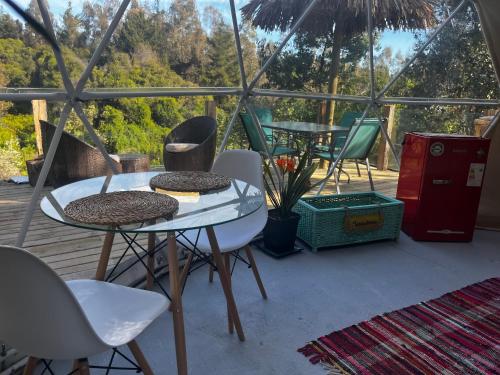 - une terrasse avec une table et des chaises dans une tente dans l'établissement OASIS PICHILEMU DOMO, à Rinconada El Sauce