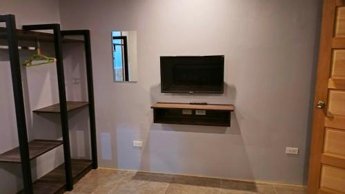 ein Wohnzimmer mit einem TV an der Wand in der Unterkunft KM Pension 