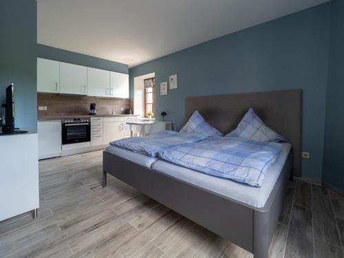a bedroom with a bed and a kitchen at A Mëchels in Bettel