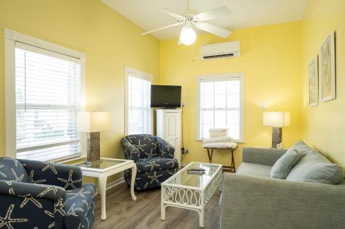 a living room with a couch and chairs and a tv at Crawl to Duval w/ Hot tub in Key West