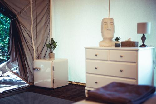 een slaapkamer met een dressoir en een hoofd aan de muur bij Boho Park Glamping in Zawiszyn