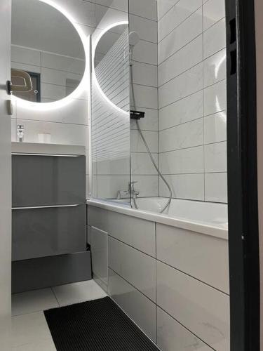 une salle de bain blanche avec une baignoire et un lavabo dans l'établissement Appartement vue sur mer, à Cannes