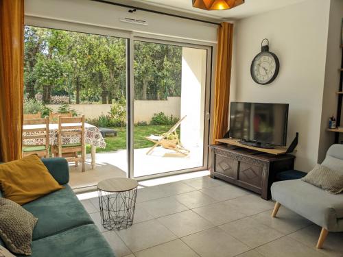 un salon avec un canapé et une télévision dans l'établissement Appartement douillet avec jardin pour 4 personnes, à Cauro