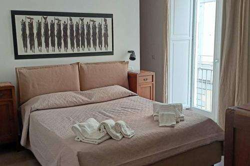 una camera da letto con un letto e asciugamani di Appartamento - Casa Madre a Napoli