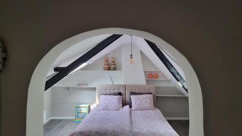 a bedroom with an arch with two beds in it at 't Bakuusje in Kamperland