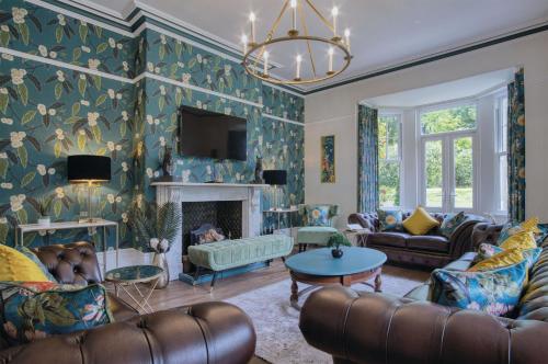 a living room with a couch and a fireplace at Hill House Country Estate - Princes Gate in Ludchurch