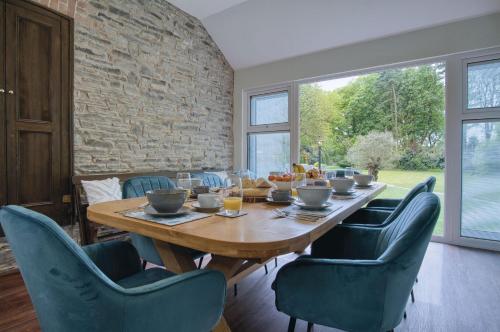 a dining room with a wooden table and blue chairs at Hill House Country Estate - Princes Gate in Ludchurch