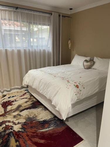 1 dormitorio con 1 cama blanca grande y ventana en Side Step, en Johannesburgo