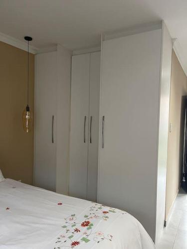 a bedroom with white cabinets and a bed at Side Step in Johannesburg
