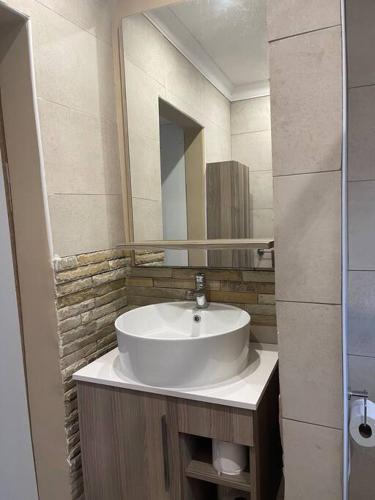a bathroom with a white sink and a mirror at Side Step in Johannesburg