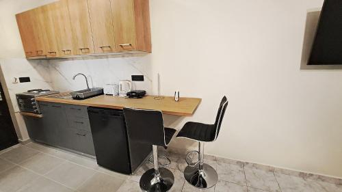 una pequeña cocina con encimera y algunas sillas en La Torre Studio, en Alikanas