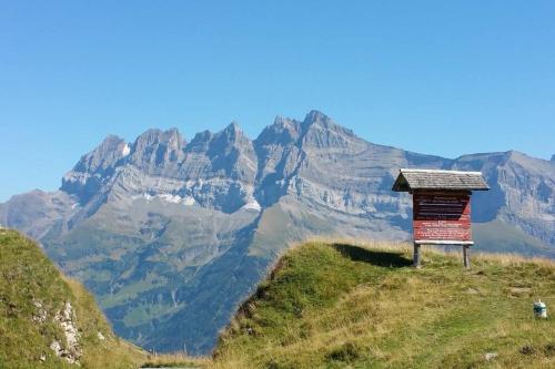 a sign on a hill with mountains in the background at Chalet le Grenier des Crosets, Vue exceptionnelle sur les Dents du Midi in Champéry