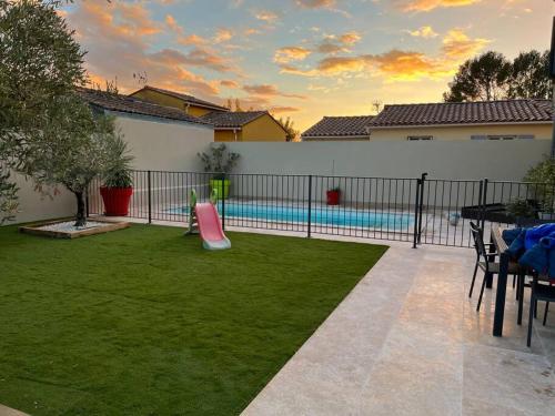 einen Hinterhof mit Pool und Spielplatz in der Unterkunft La villa castellas in Carpentras