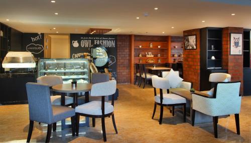 a restaurant with chairs and tables and a counter at Sovereign Bali Hotel in Kuta