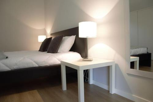 een slaapkamer met een bed en een tafel met een lamp bij EiraDouro - Casa Oliveira 