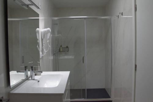 a bathroom with a glass shower and a sink at EiraDouro - Casa Oliveira in Mós